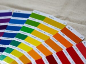 虹色のグラデーションに広がる塗料カラーチップのサンプル帳