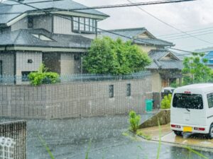 激しい雨が降りしきる住宅街の風景